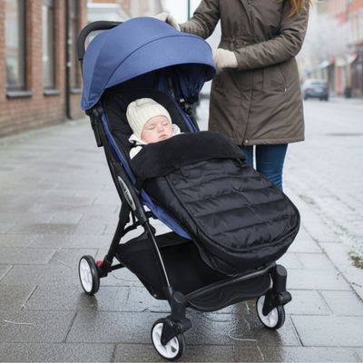 Bébé au chaud dans une chancelière poussette noire imperméable et coupe-vent